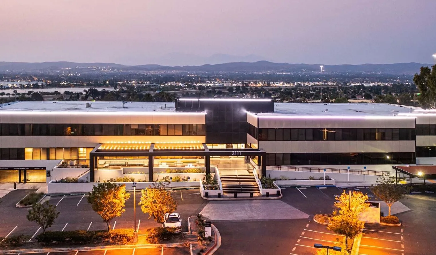 Landscaped commercial office property illuminated at dusk
